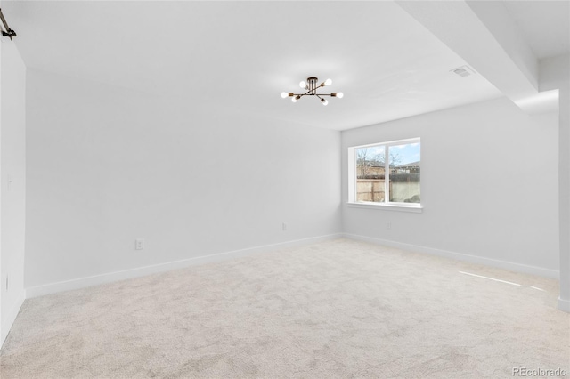 unfurnished room featuring light carpet and a notable chandelier