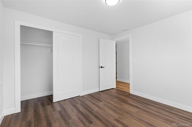 unfurnished bedroom with a closet and dark hardwood / wood-style flooring