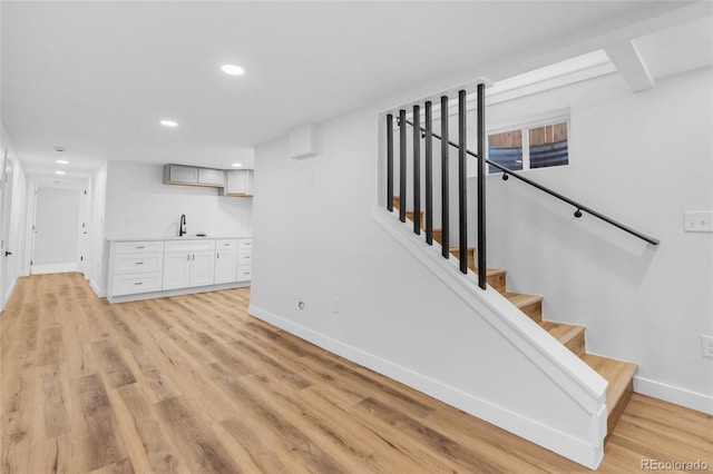 stairway featuring sink and hardwood / wood-style flooring