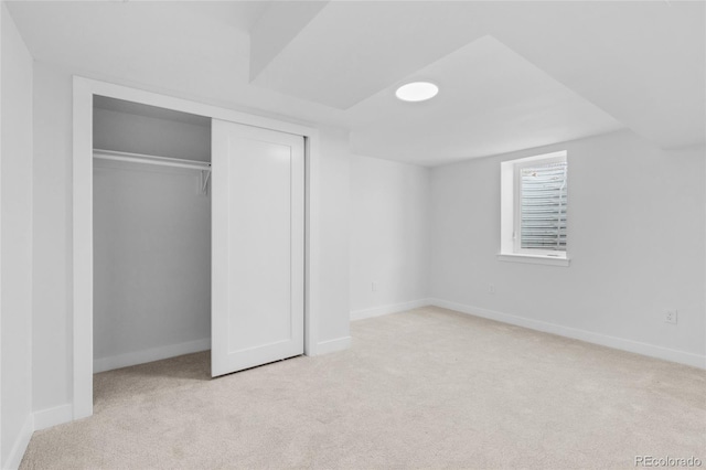 unfurnished bedroom with a closet and light carpet