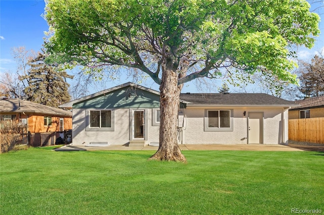 rear view of property featuring a patio area and a lawn