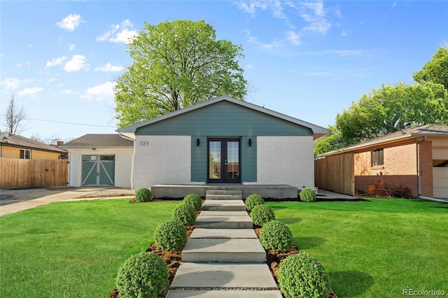 single story home with a garage, a front yard, and french doors