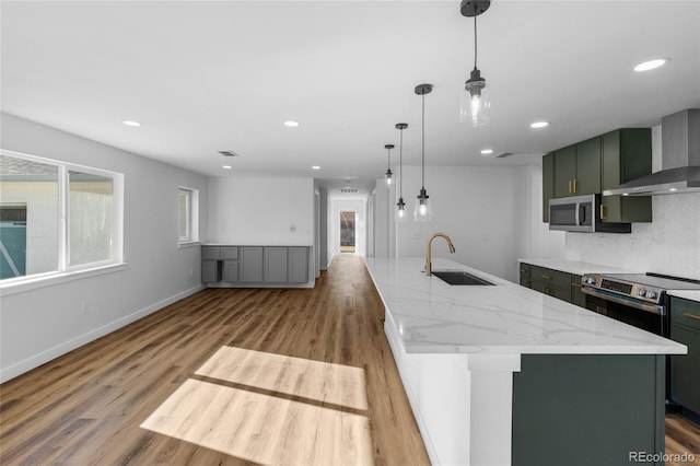 kitchen featuring light stone counters, sink, a center island with sink, and stainless steel appliances