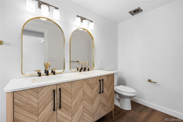 bathroom featuring vanity, toilet, and wood-type flooring