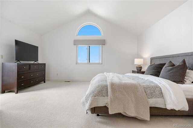 bedroom with baseboards, light colored carpet, and vaulted ceiling