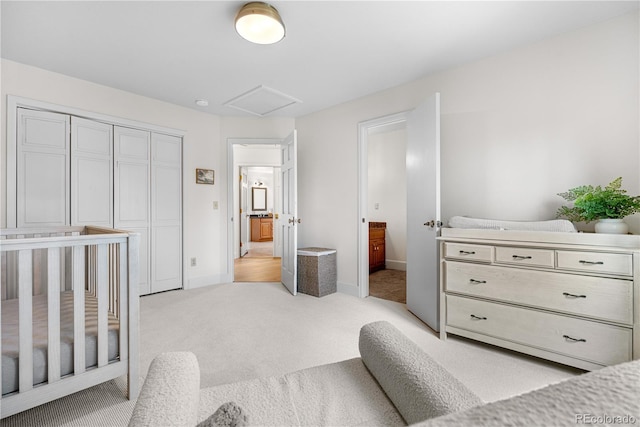 bedroom featuring baseboards, light carpet, attic access, and a closet