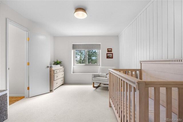 bedroom with a crib and light carpet