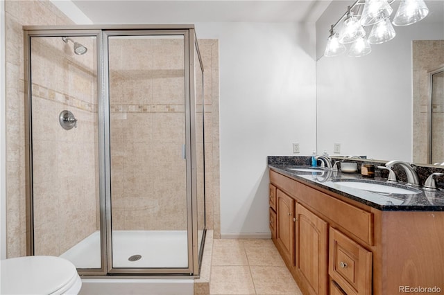 full bath with tile patterned flooring, a sink, toilet, and a shower stall