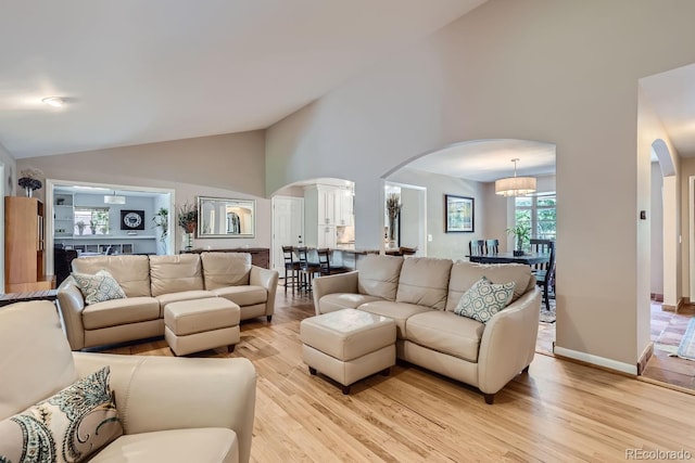 living room featuring light hardwood / wood-style flooring and high vaulted ceiling