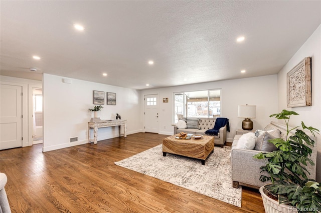 living room with recessed lighting, visible vents, a textured ceiling, wood finished floors, and baseboards