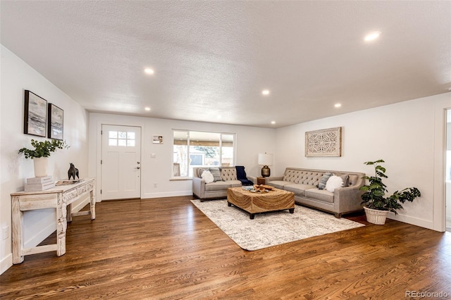 living area with recessed lighting, a textured ceiling, baseboards, and wood finished floors