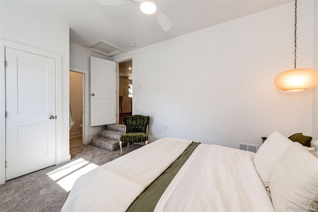 carpeted bedroom featuring ceiling fan, visible vents, and attic access