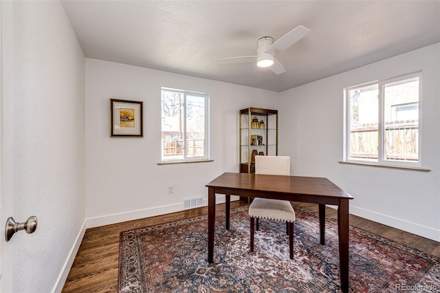 office featuring baseboards, ceiling fan, visible vents, and wood finished floors