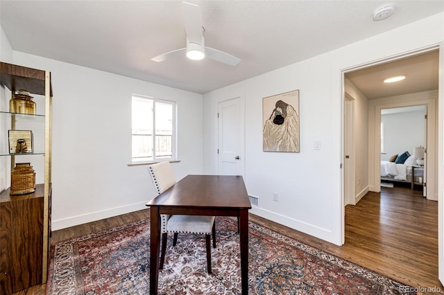 office space with a ceiling fan, visible vents, baseboards, and wood finished floors