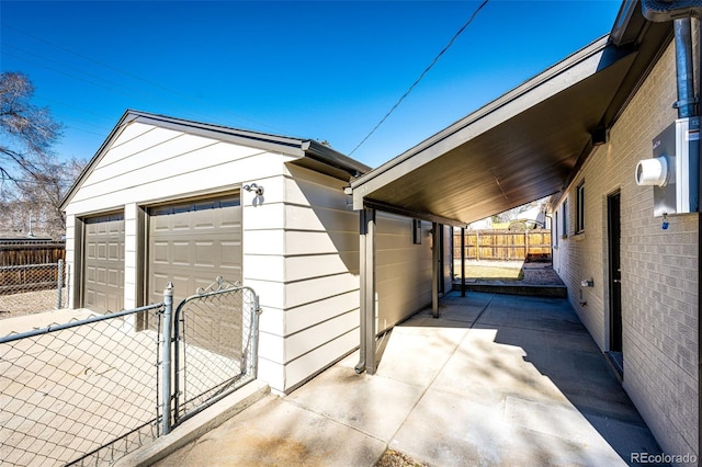 view of side of home featuring a garage, an outbuilding, a gate, and fence