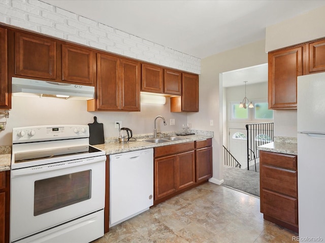 6869 Quay St, Arvada, CO 80003 - kitchen with white appliances, under cabinet range hood, a sink, and brown cabinets