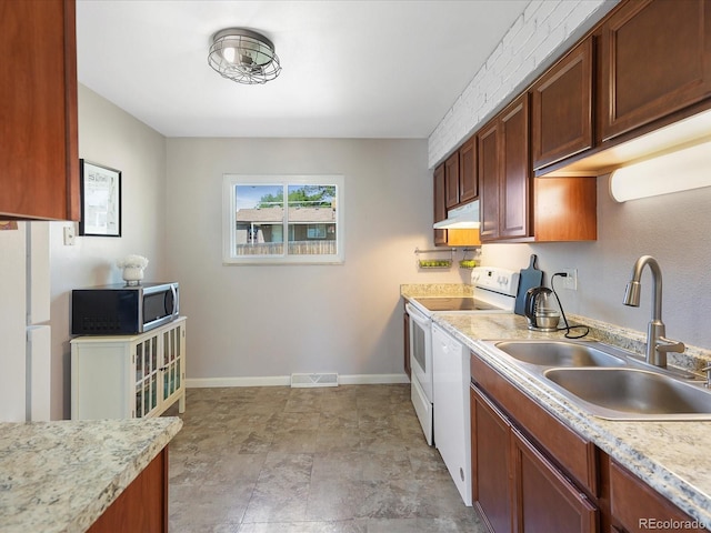 6869 Quay St, Arvada, CO 80003 - kitchen with white appliances, under cabinet range hood, a sink, light countertops, and baseboards