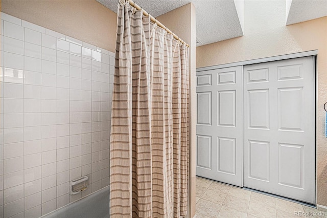 bathroom with shower / bath combination with curtain and a textured ceiling