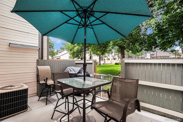 view of patio with outdoor dining space, fence, and central air condition unit