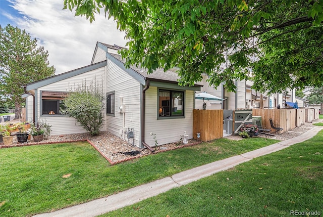 view of side of property featuring a yard and fence