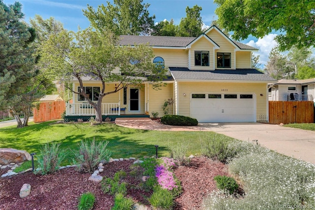 traditional home featuring driveway, a front lawn, fence, covered porch, and an attached garage