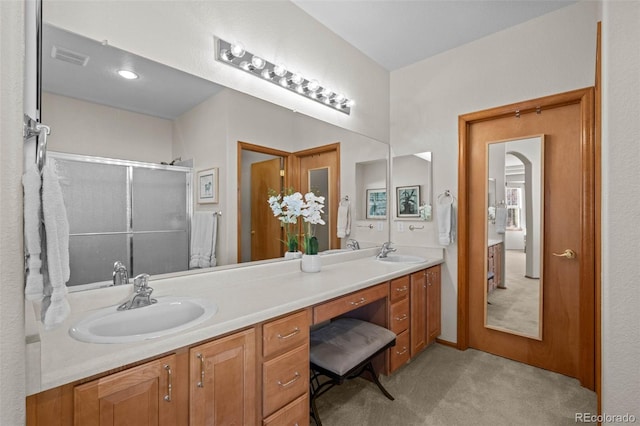 bathroom with vanity and a shower with door