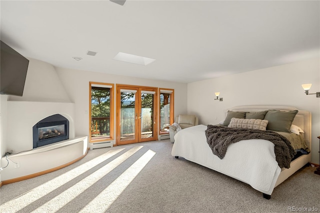 28890 Pinewood Vista Dr, Evergreen, CO 80439 - carpeted bedroom with visible vents, a skylight, access to exterior, a fireplace, and a baseboard radiator
