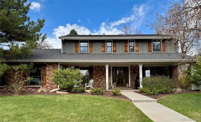 traditional-style house with a porch, brick siding, and a front yard