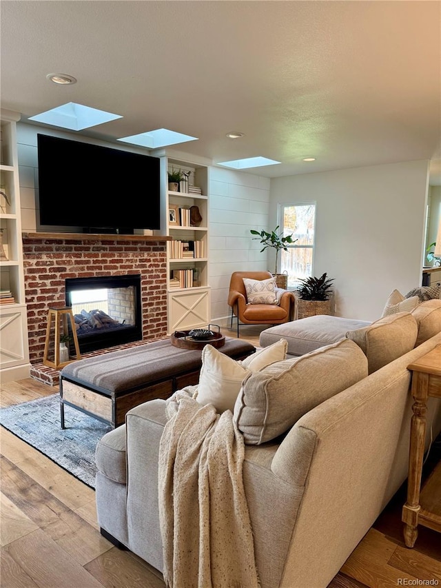 8503 E Jamison Ave, Centennial, CO 80112 - living area featuring a brick fireplace, wood finished floors, and a skylight