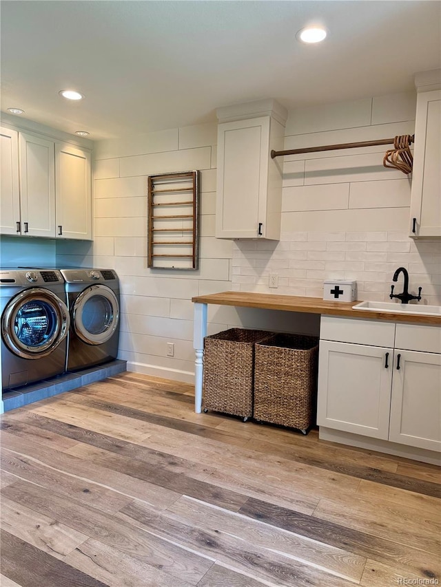 8503 E Jamison Ave, Centennial, CO 80112 - laundry area with cabinet space, washing machine and clothes dryer, a sink, light wood finished floors, and recessed lighting