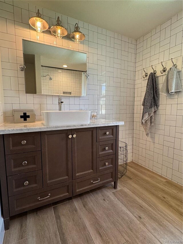 8503 E Jamison Ave, Centennial, CO 80112 - bathroom featuring tile walls, backsplash, vanity, and wood finished floors