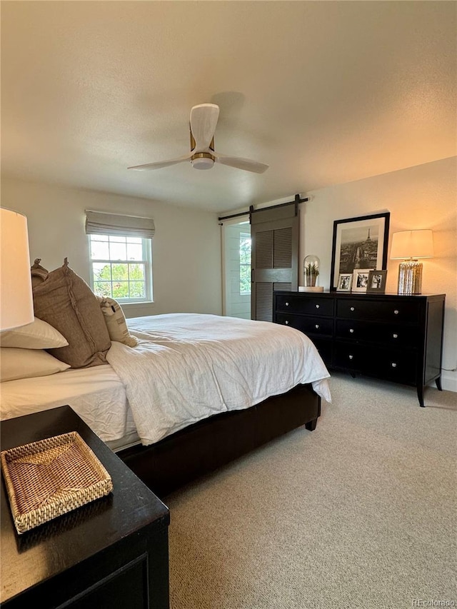 8503 E Jamison Ave, Centennial, CO 80112 - bedroom featuring light carpet, a ceiling fan, and a barn door