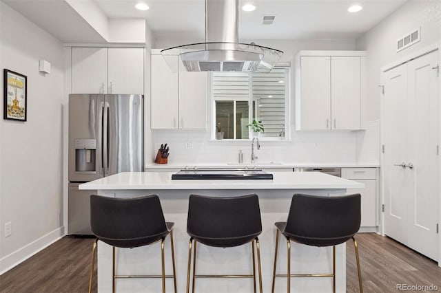 1284 Quitman St, Denver, CO 80204 - kitchen with stainless steel fridge with ice dispenser, a kitchen island, dark wood finished floors, a kitchen breakfast bar, and recessed lighting