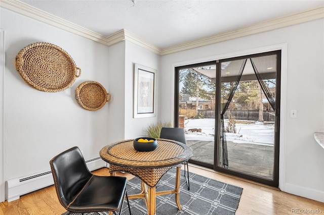 dining space with light wood-type flooring, baseboards, a baseboard heating unit, and ornamental molding