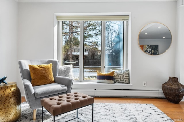 sitting room with baseboard heating and light wood-style floors