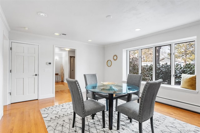 dining room featuring light wood-style floors, a baseboard radiator, crown molding, and recessed lighting