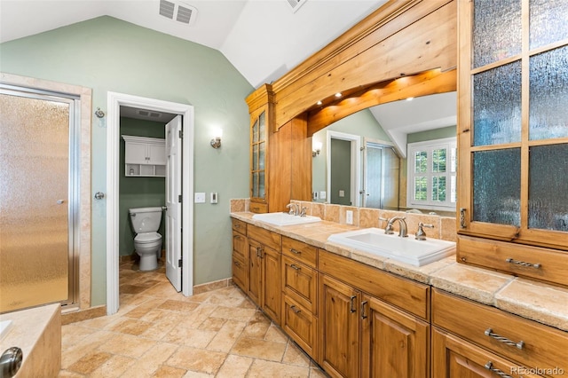 full bath with visible vents, vaulted ceiling, and a sink