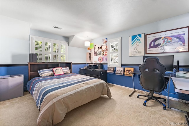 bedroom featuring visible vents and light colored carpet