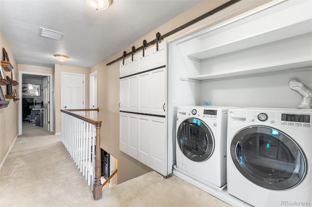 laundry room featuring laundry area, a barn door, visible vents, light colored carpet, and washing machine and dryer