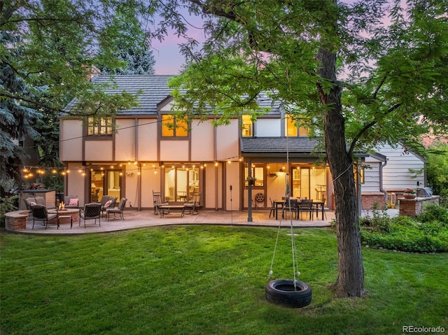 rear view of house with stucco siding, a patio area, a lawn, and an outdoor hangout area