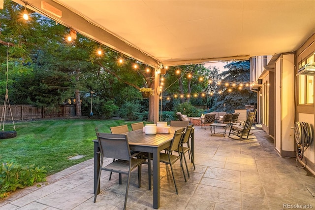 patio terrace at dusk with a fenced backyard, an outdoor hangout area, a lawn, and outdoor dining space