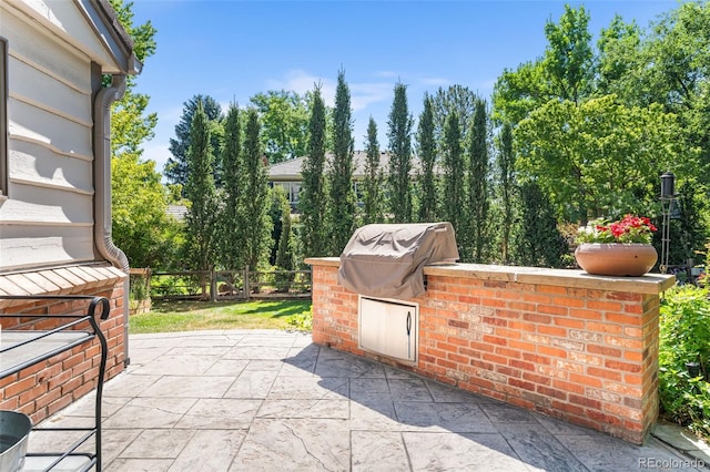 view of patio featuring a grill, area for grilling, and fence