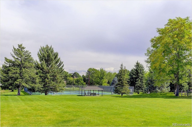 view of property's community with a yard and fence