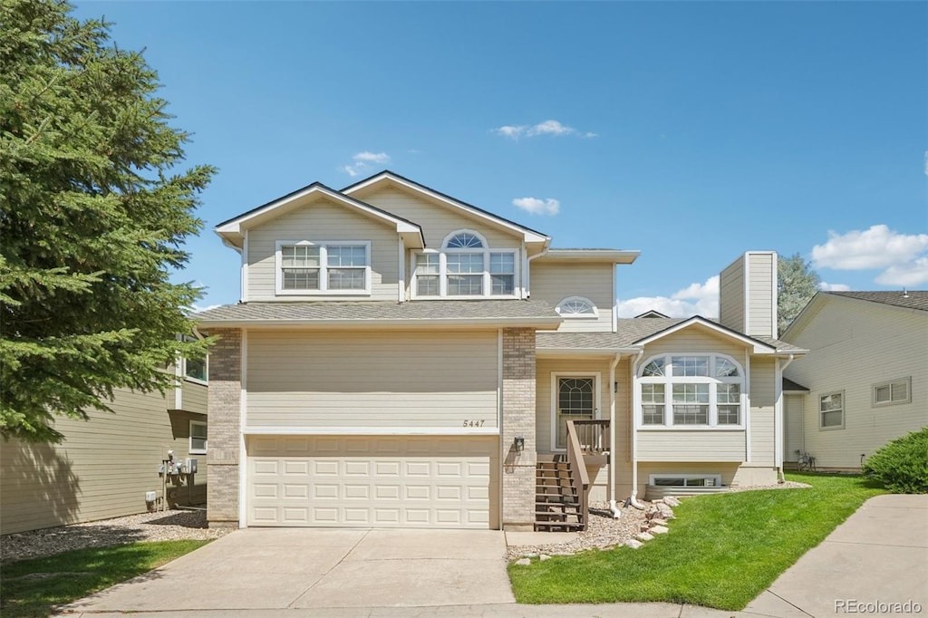 5447 Lions Gate Ln, Colorado Springs, CO 80919 - view of front of property featuring an attached garage, concrete driveway, a front yard, and brick siding