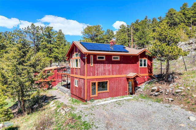 548 Coughlin Meadows Rd, Boulder, CO 80302 - rear view of property featuring roof mounted solar panels and a deck