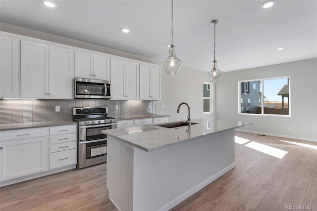 13502 E 100th Ave, Commerce City, CO 80022 - kitchen with appliances with stainless steel finishes, a sink, decorative backsplash, light wood finished floors, and recessed lighting
