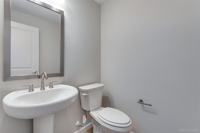 13502 E 100th Ave, Commerce City, CO 80022 - bathroom featuring toilet, a sink, and baseboards