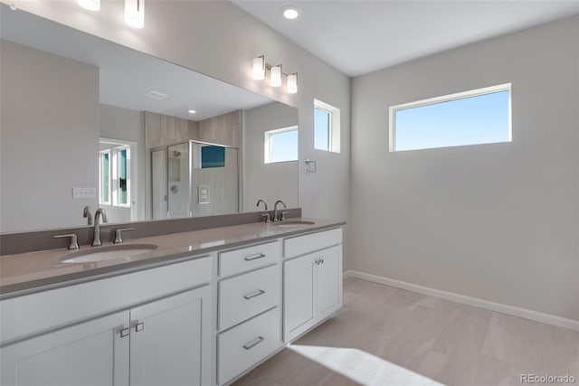 13502 E 100th Ave, Commerce City, CO 80022 - bathroom featuring a stall shower, double vanity, baseboards, and recessed lighting