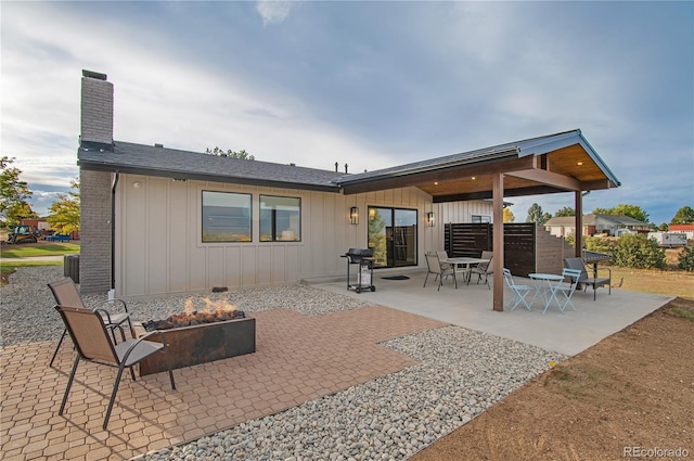 rear view of property with a patio area and an outdoor fire pit