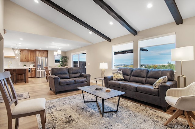 living room with lofted ceiling with beams and light hardwood / wood-style flooring